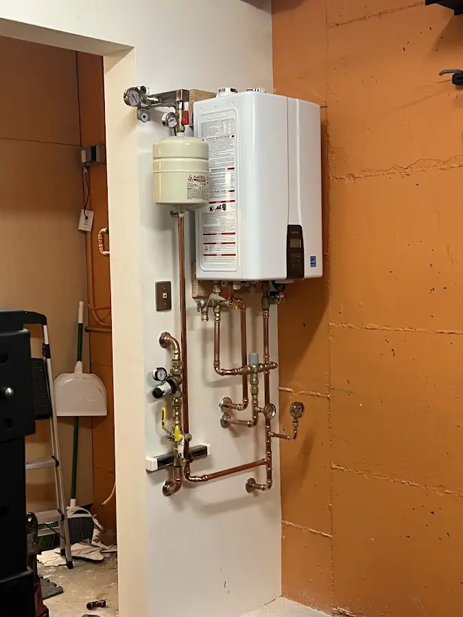 Plumbing technician inspecting water heater connections in Malabar